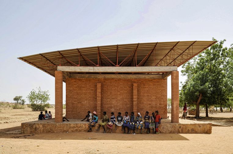 During recess, the children sit in the shade of the large roof of Gando Primary School.  Photo by Erik-Jan Ouwerkerk / ANP