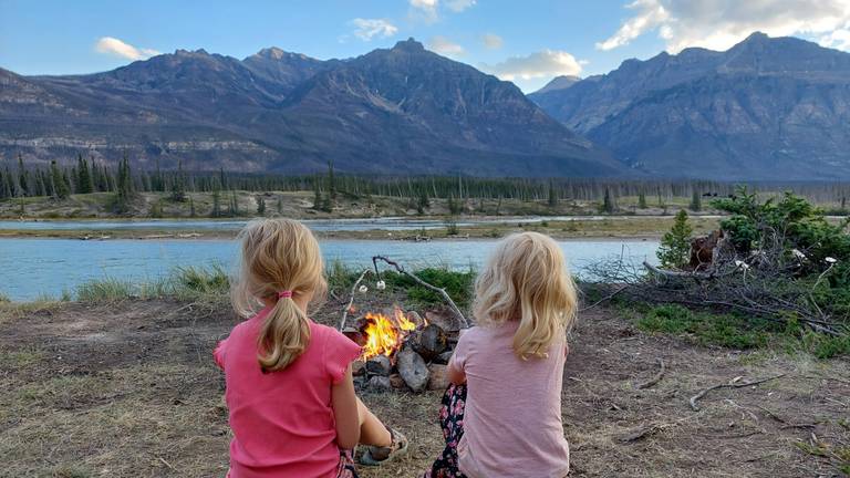 Tess and Gwen roast marshmallows over a fire in Canada