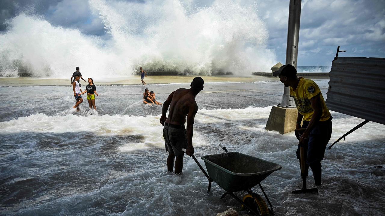 Ian also caused a lot of damage in western Cuba.  Here, municipal workers clear up the chaos in Havana as they watch children playing in the water.